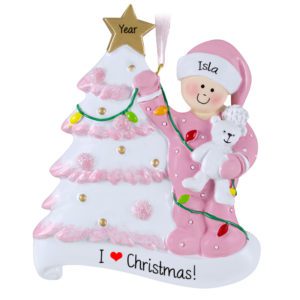 Little Girl Decorating Glittered Tree And Holding Bear Ornament PINK